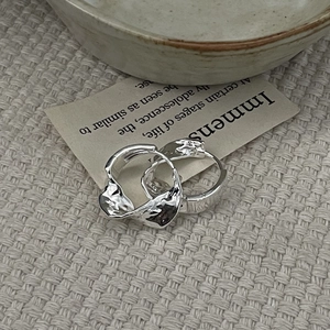 Detail of S925 sterling silver hoop earrings with irregular lava texture and glossy finish