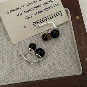 Détail de créoles en argent S925 avec perles d'œil de tigre et onyx noir