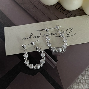 Detailed close-up of 925 sterling silver beaded stud earrings on elegant gift card