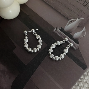 Macro shot of S925 sterling silver beaded hoop earrings with textured brushed metal finish