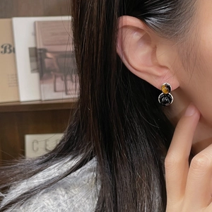 Boucles d'oreilles en argent S925 avec œil de tigre et onyx noir portées par un mannequin