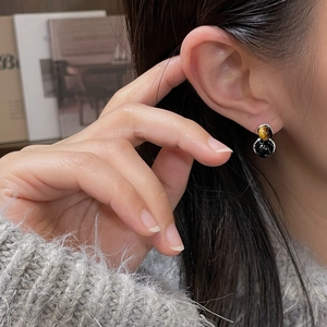 Gros plan de boucles d'oreilles en argent S925 avec oeil de tigre et agate noire