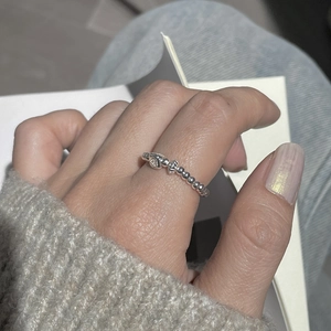 Detailed view of an S925 sterling silver beaded ring with heart accent on index finger