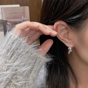 Close-up of irregular textured silver S925 earrings on model with warm autumn vibe