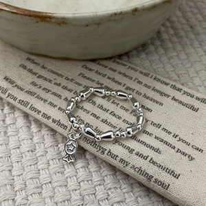 Minimalist S925 sterling silver beaded ring with a small star pendant on fabric