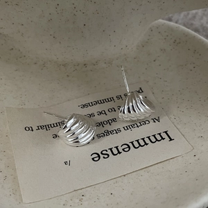Gros plan sur boucles d'oreilles coquillage en argent S925 à texture spirale