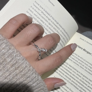 Close-up of a S925 sterling silver beaded ring with star charm on hands with a book