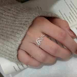 Detailed close-up of hollow double heart S925 sterling silver ring worn on finger