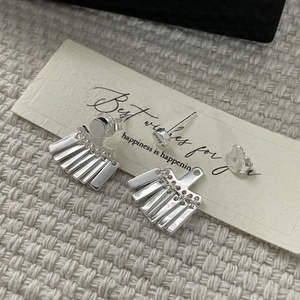 Boucles d'oreilles pompons en argent sterling S925 poli sur fond élégant et texturé