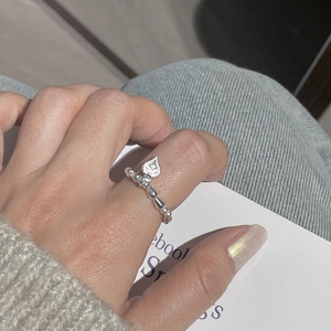 Detail of S925 sterling silver heart charm ring with beaded band on finger