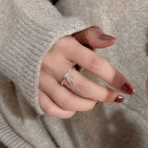 Elegant S925 sterling silver hollow heart open ring on model with beige sweater