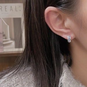 Classic silver hoops with square-cut blue zircon stones shown on a female ear