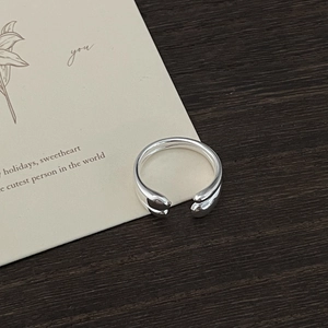 Macro detail of silver adjustable ring featuring a unique hugging hands design