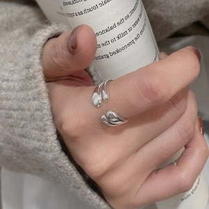 Detailed view of an asymmetric double water drop open ring in polished 925 silver