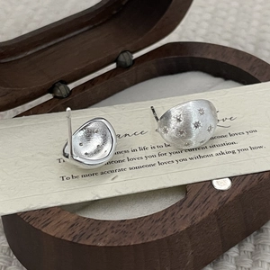 Detailed macro view of hemispherical S925 sterling silver studs with star engraving