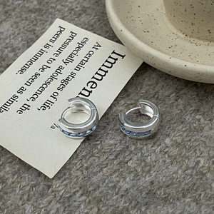 Silver thick hoop earrings with channel-set blue rectangular zircons on knit background