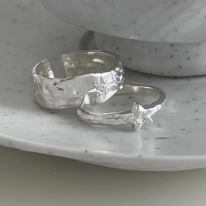 Minimalist 925 sterling silver star rings with irregular hammered texture on ceramic base