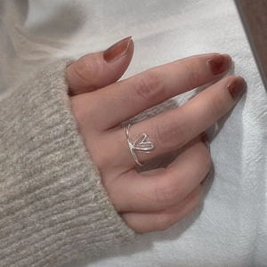 Close-up of S925 sterling silver heart ring worn on finger with a knit sweater background