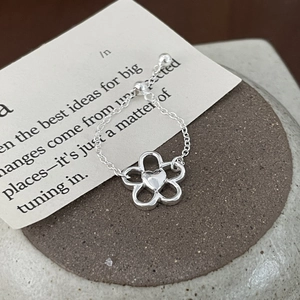 S925 sterling silver flower adjustable chain ring with heart detail on a textured base