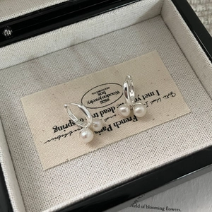 Gros plan de boucles d'oreilles vintage en argent S925 et perles sur carte à bijoux