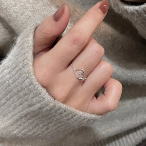 Detailed view of an adjustable 925 silver heart ring on a grey knit sweater background