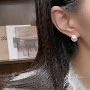 Minimalist S925 sterling silver star stud earring with a brushed matte texture on model