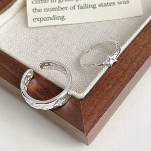 Detail of 925 sterling silver adjustable rings featuring embossed star patterns