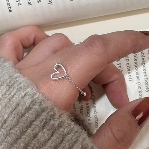 Close-up of a 925 sterling silver hollow heart ring with adjustable bead chain on finger
