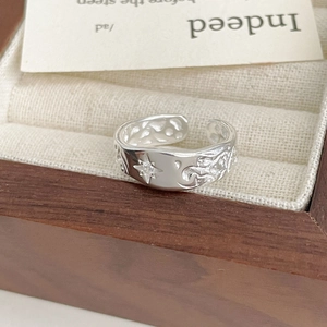 Macro shot of silver star and moon ring with cubic zirconia in a wooden jewelry box