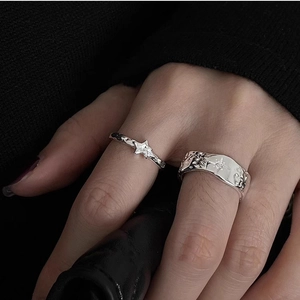 Detailed close-up of 925 silver rings with star motifs and textured lava finish on a hand