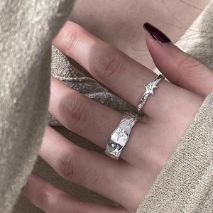 Macro shot of 925 silver irregular textured rings with star engraving and zircon details
