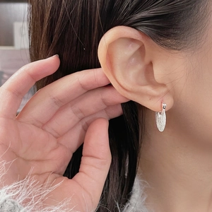 Detailed view of S925 sterling silver hoop earrings with brushed oval leaf pendants