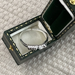 Vue détaillée de la bague nouée en argent 925 sur un écrin à bijoux vert de style vintage