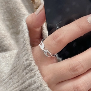 Macro shot of silver quilted buckle ring worn with a soft grey knit sweater