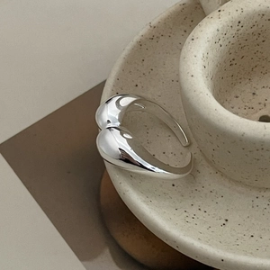 Artistic detail of adjustable S925 sterling silver wide ring on a ceramic tea set cup
