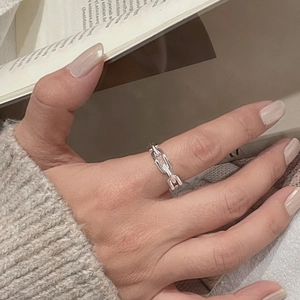 Close-up of a silver chain link ring on a hand with a minimalist aesthetic style