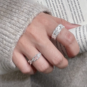 Detailed close-up of S925 sterling silver braided twist and chain rings on fingers
