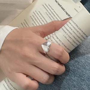 Bague cœur en argent sterling S925 poli portée à l'index dans un décor de style de vie