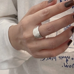 Détail d'une bague large en argent S925 avec texture martelée portée sur le doigt