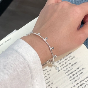 Detailed view of S925 sterling silver beaded bracelet featuring a small heart pendant on wrist