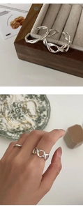 Detail of twisted woven sterling silver open ring on wooden jewelry display box