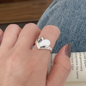 Gros plan d'une bague cœur en argent sterling S925 poli portée par un mannequin