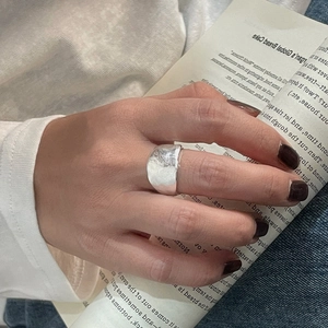 Détail d'une bague large en argent S925 avec texture martelée portée à la main