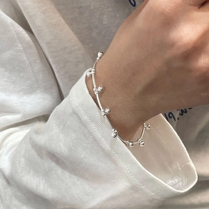 Close-up of minimalist S925 sterling silver bead bracelet on a female model wrist