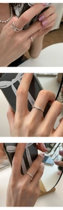 Close-up of minimalist S925 sterling silver infinity and twisted rope rings on fingers