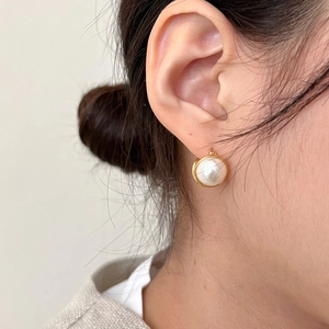 Elegant 925 sterling silver gold pearl earrings shown on a model for a chic minimalist look