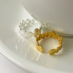 Dettaglio di anelli aperti in argento sterling S925 con design a onde irregolari minimaliste