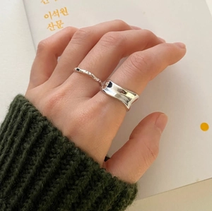 Detail view of hammered and concave 925 silver rings worn on finger with minimalist style