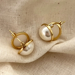 Detail of 925 sterling silver gold earrings with pearls on textured linen fabric