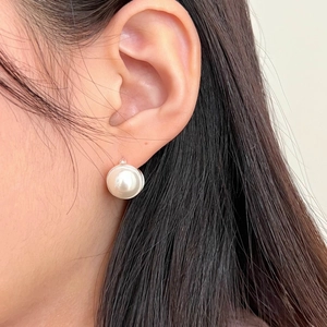Close-up of elegant 925 sterling silver pearl hoop earring worn on a model earlobe